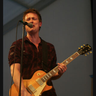 Jonny Lang performing with guitar, full head and both hands visible