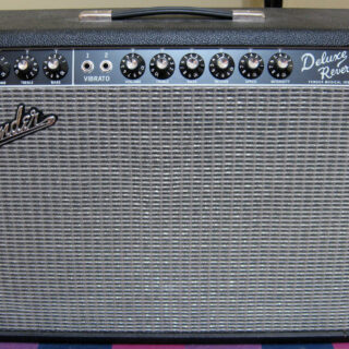 Front view of a Fender Deluxe Reverb amplifier with its cabinet, handle and control panel visible.