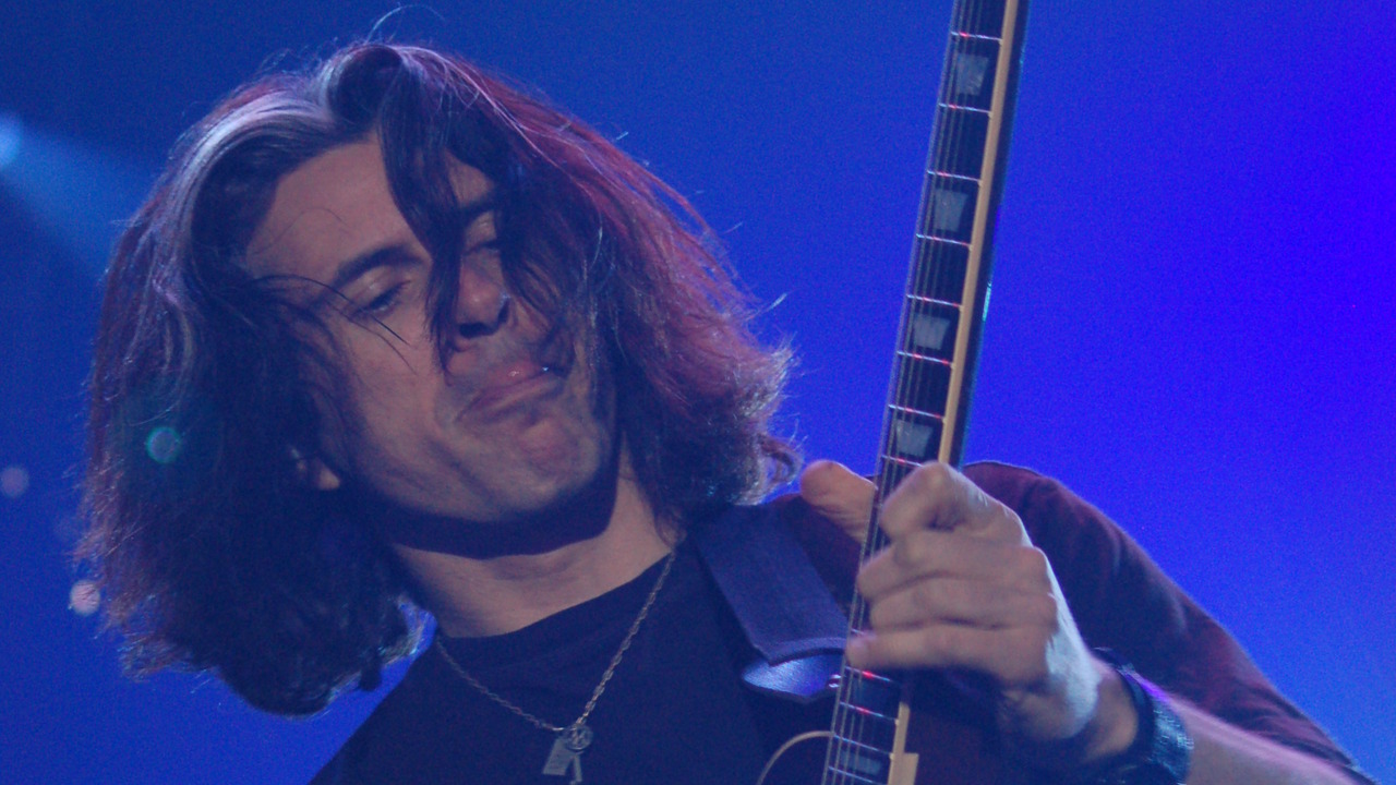 Alex Skolnick playing guitar with Testament at Metalmania 2007, shown in a blue-lit close-up with his fretting hand visible.