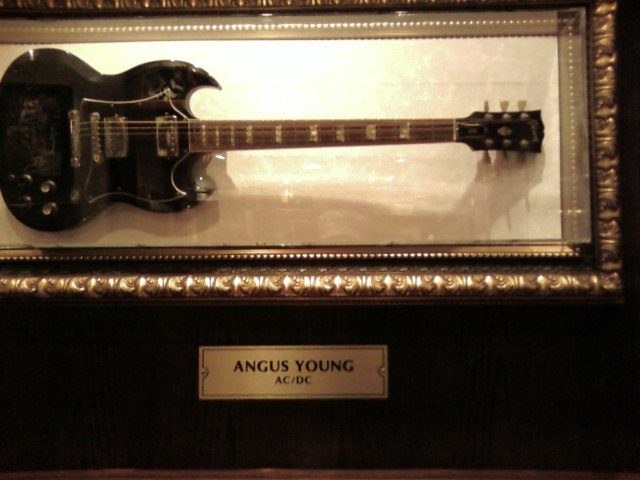 a Gibson SG played by Angus Young, displayed with his name plate.