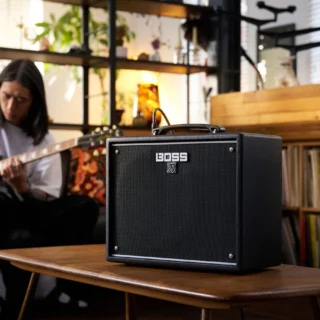 BOSS KATANA-25 amplifier with a guitarist playing in the background in a manufacturer promotional photograph