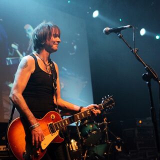 Brian Robertson performing with a Les Paul guitar