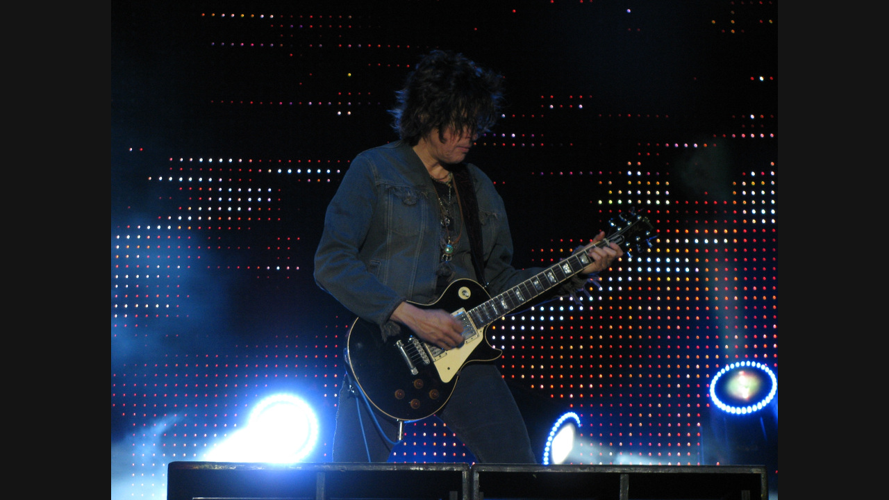 Dean DeLeo performing with Stone Temple Pilots at Ottawa Bluesfest in July 2009, with both hands and the complete black electric guitar visible.