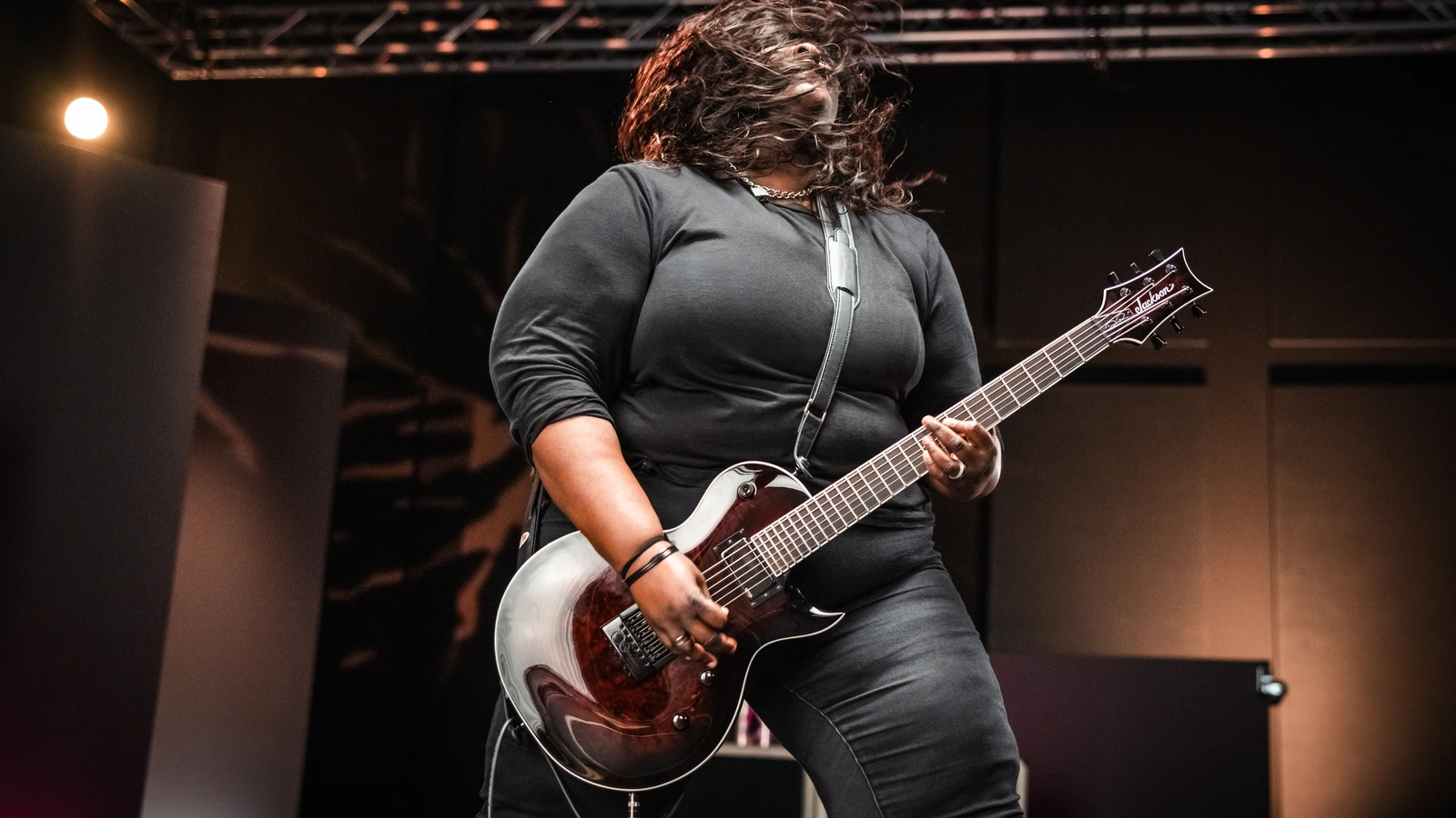 Diamond Rowe playing her Dark Rose Jackson signature guitar in a 2024 promotional photograph.