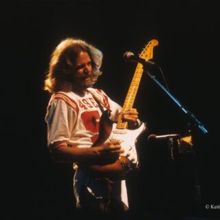 Don Felder playing a Fender Stratocaster on stage.