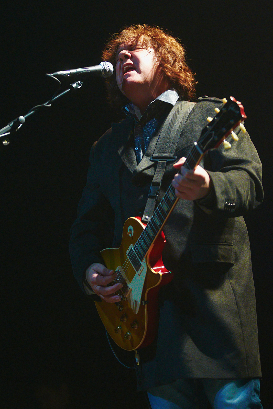 Gary Moore singing and playing a sunburst Les Paul onstage in 2010.