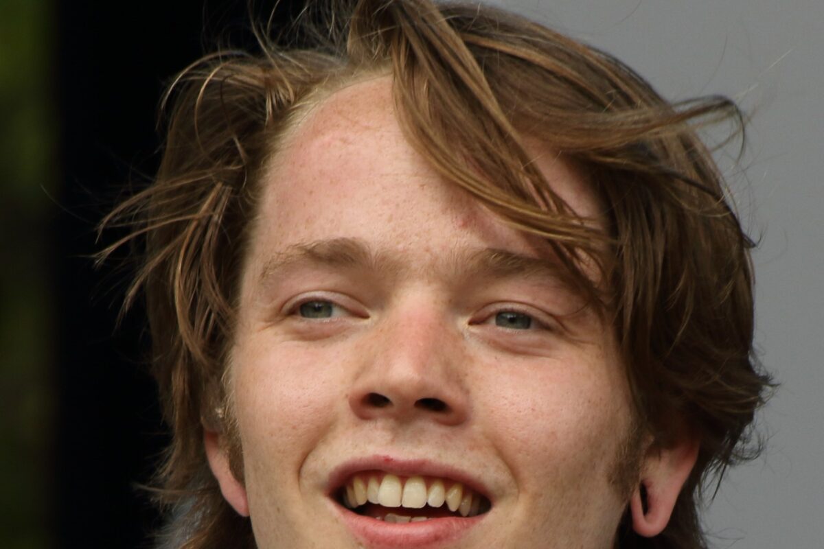 Billy Strings smiling, close-up portrait.