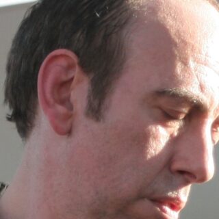Mick Jones of The Clash, shown in a head-and-upper-torso portrait at SXSW in 2008.