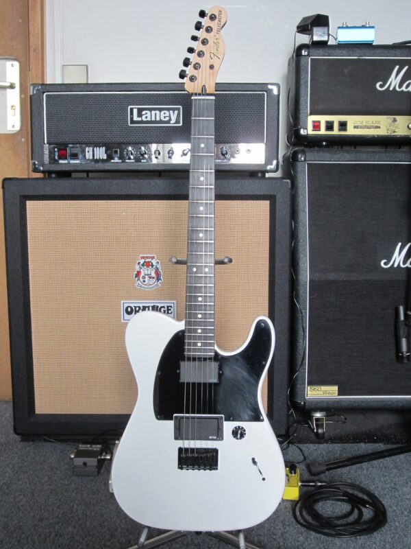 Flat white Fender Jim Root Telecaster with black pickguard, two black humbuckers and ebony fingerboard, standing in front of Laney, Orange and Marshall amps.