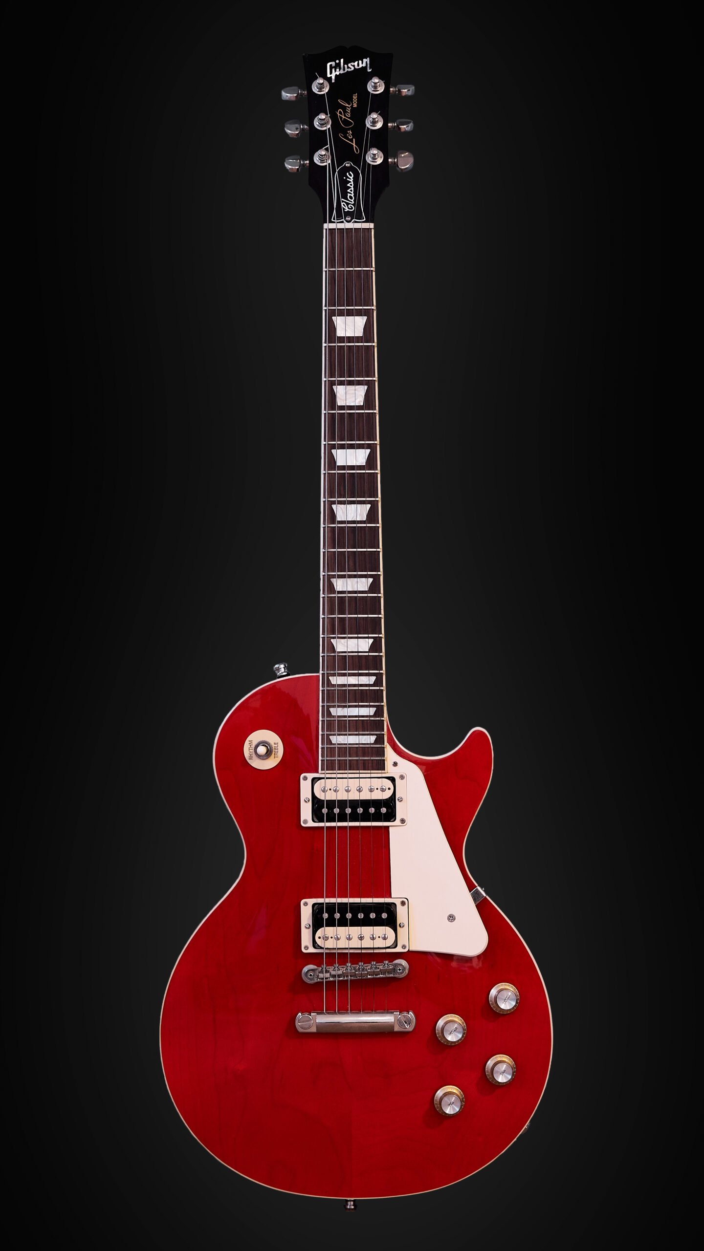 Full-length red Gibson Les Paul Classic with zebra humbuckers against a dark background.