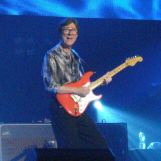 Hank Marvin playing a red Stratocaster on The Shadows' 50th anniversary tour in 2009.