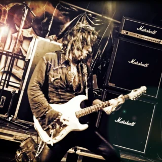 Joe Stump playing a white guitar at R-Mine Metalfest in Belgium in 2013.