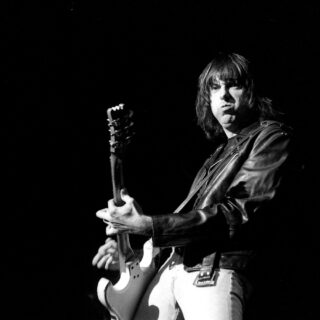 Johnny Ramone playing a white electric guitar at Club Citta in Kawasaki in 1990, photographed by Masao Nakagami.