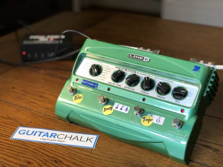 A green Line 6 DL4 delay pedal with all controls, four footswitches and user labels visible on a wooden surface.