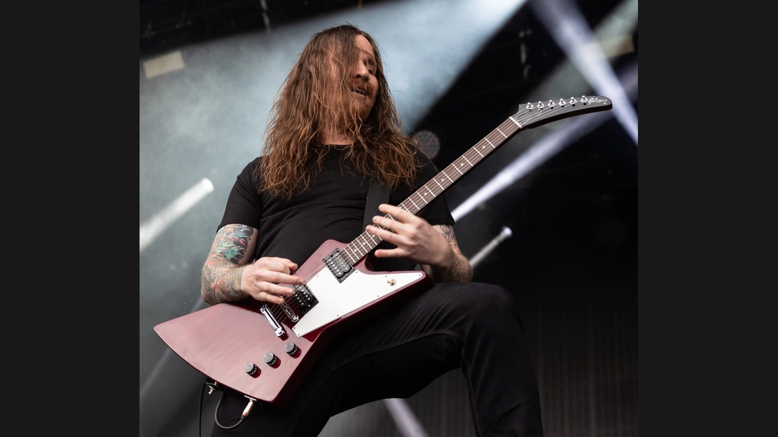 Historical photograph of Power Trip guitarist Nick Stewart playing a reddish Gibson Explorer at Rock am Ring in 2019.