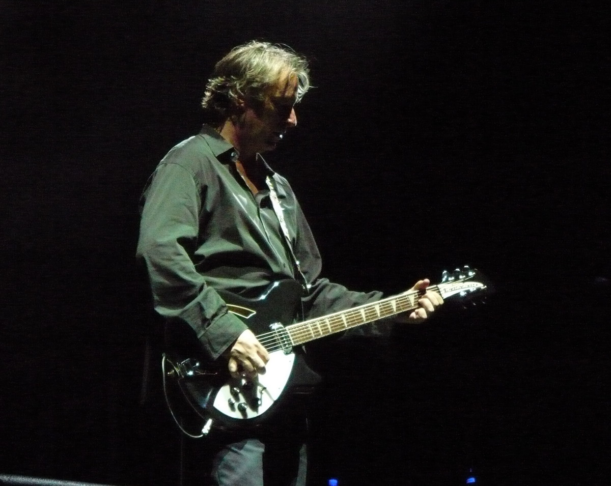 Peter Buck playing a black Rickenbacker onstage in Naples in 2008, with the whole guitar visible.