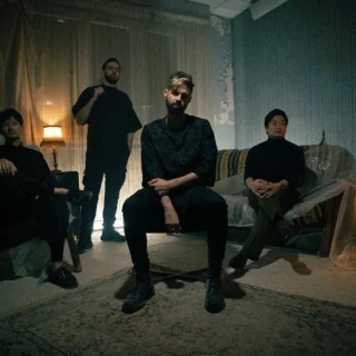 The four members of REVNOIR in a promotional band photograph