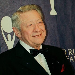 Scotty Moore in a black tuxedo and bow tie at an induction ceremony.