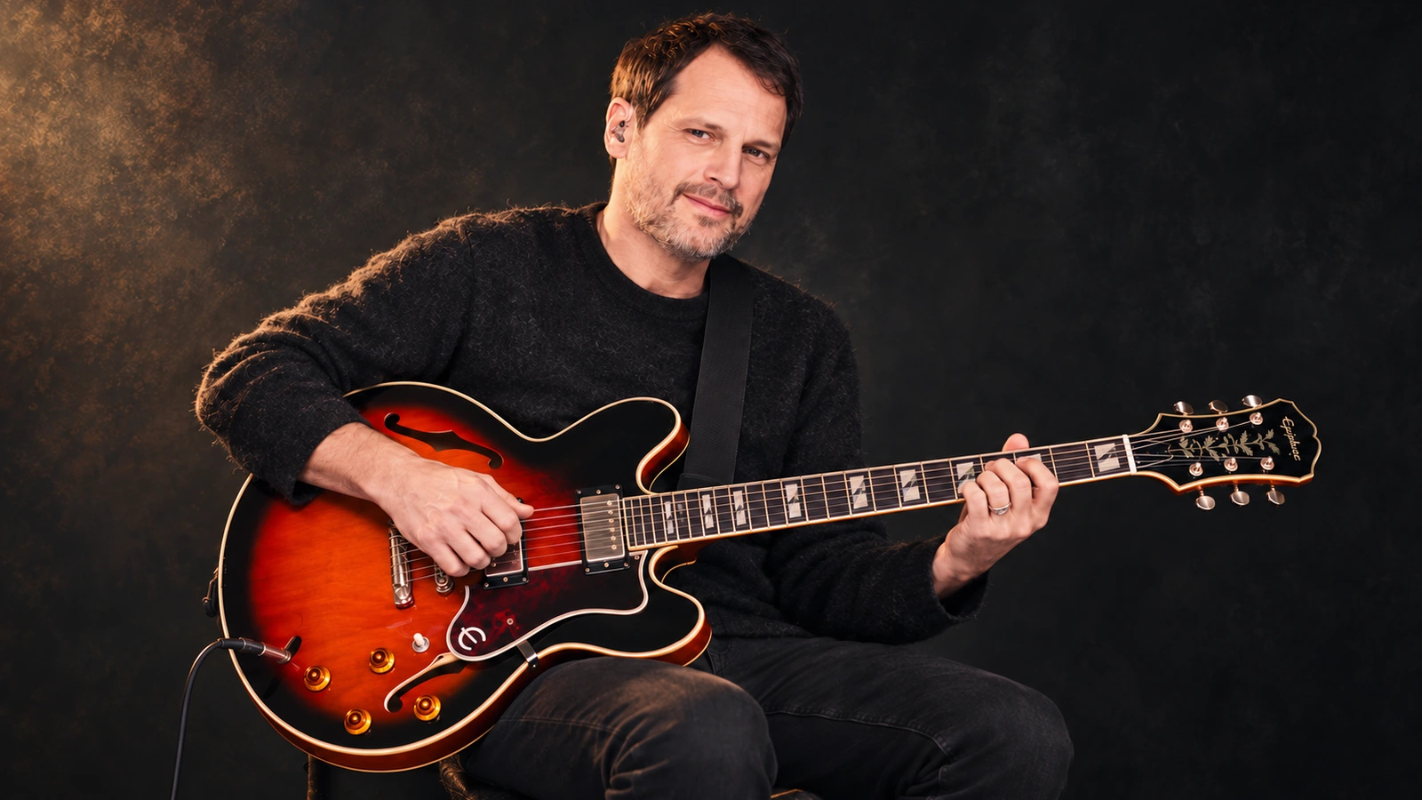 Editorial illustration of Brian Aubert holding a sunburst Epiphone semi-hollow guitar.