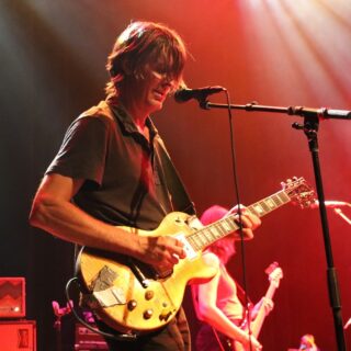 Stephen Malkmus playing a single-cut electric guitar onstage with the Jicks.