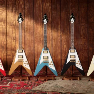 Five Gibson Tom Petty Flying V 50th Anniversary guitars in red, gold, blue, graphite and white.