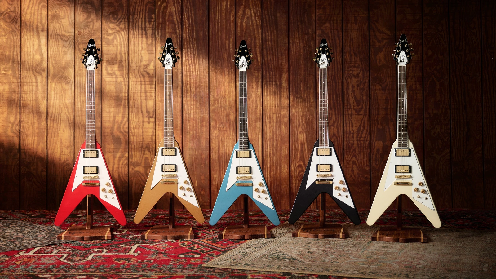 Five Gibson Tom Petty Flying V 50th Anniversary guitars in red, gold, blue, graphite and white.