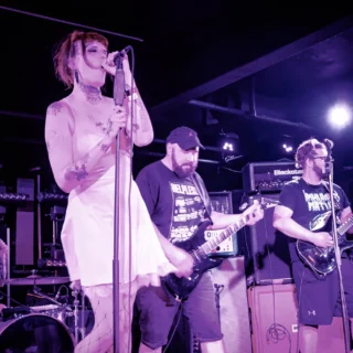 Underdark performing at Electrowerkz in London in 2022, with the singer and two electric guitarists visible.