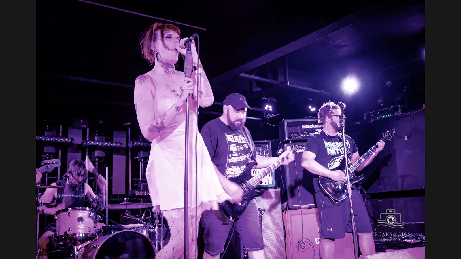 Underdark performing at Electrowerkz in London in 2022, with the singer and two electric guitarists visible.
