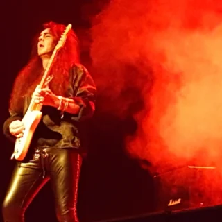 Yngwie Malmsteen playing an electric guitar at a workshop in Florianópolis in 2016.