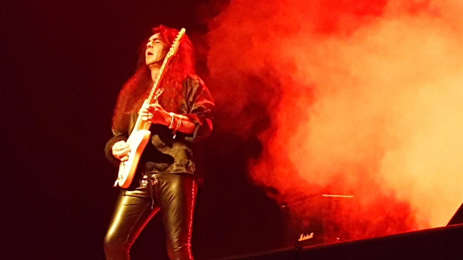 Yngwie Malmsteen playing an electric guitar at a workshop in Florianópolis in 2016.